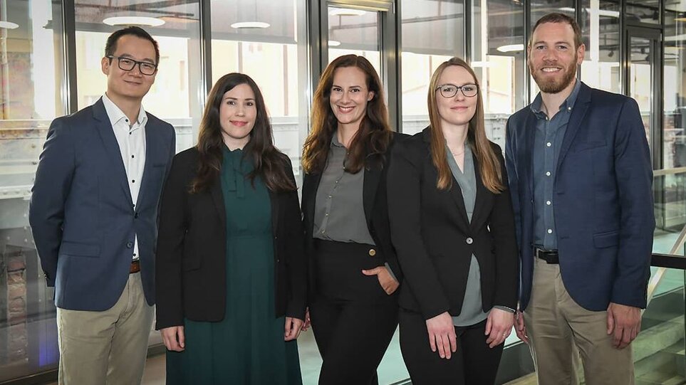 Two men and three women from the WHU MBA Recruiting Team stand in a row and smile into the camera